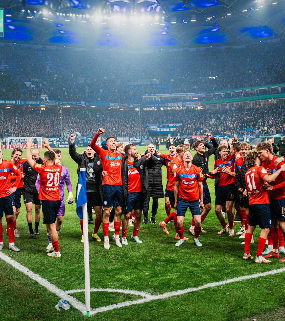 Jubelnde Kieler Spieler zelebrieren ihren Sieg gegen den HSV vor der Kurve