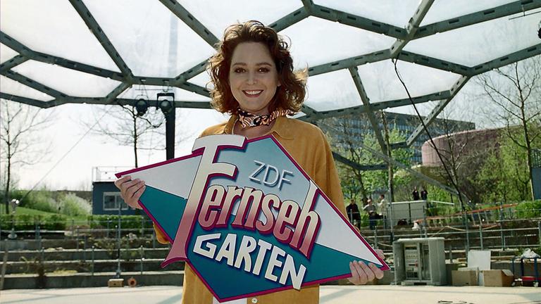 Ramona Leiss hält das Fernsehgarten Schild in der Hand