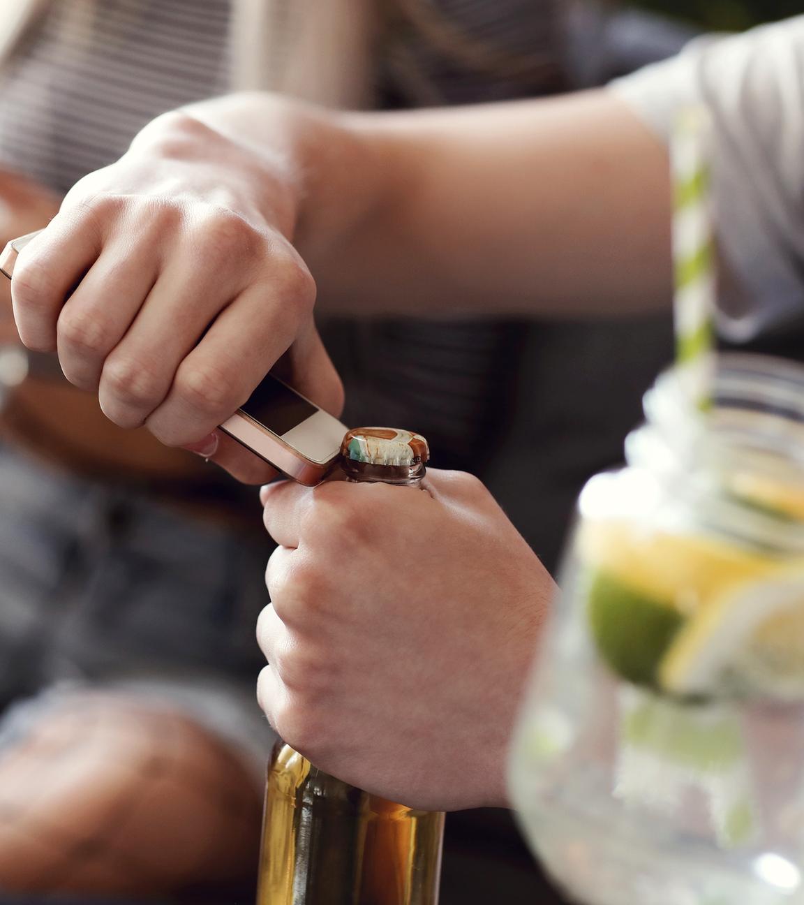 Junger Mann öffnet eine Bierflasche