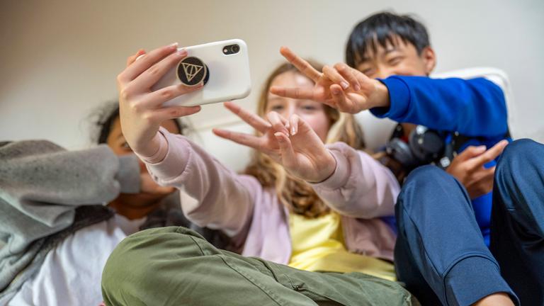 Drei Kinder machen ein Selfie mit einem Smartphone