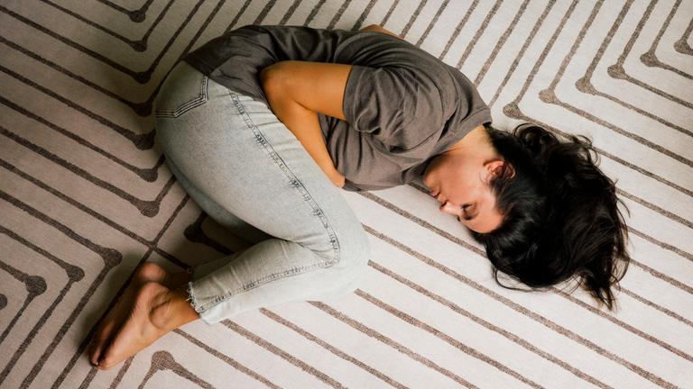 Jugendliche liegt einsam und verzweifelt auf Boden