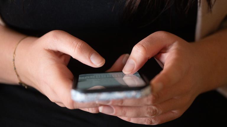 Sachsen, Dresden: Eine Jugendliche tippt auf einem Smartphone.