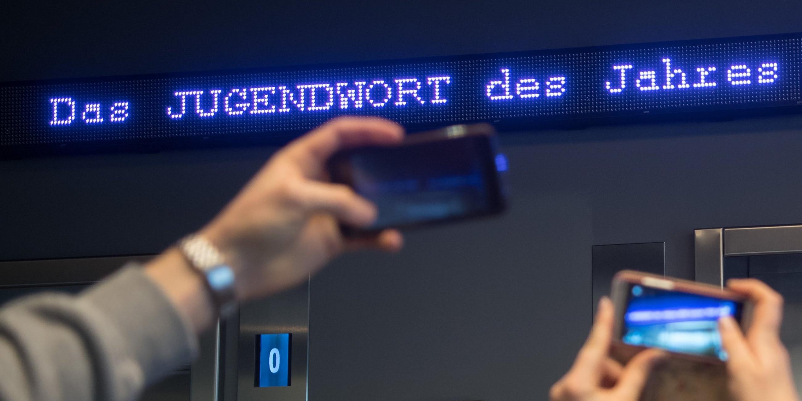 Bayern, München: Auf einem Laufband erscheint "Jugendwort des Jahres" über den digitalen Newsticker eines Hotels in München. Archivbild