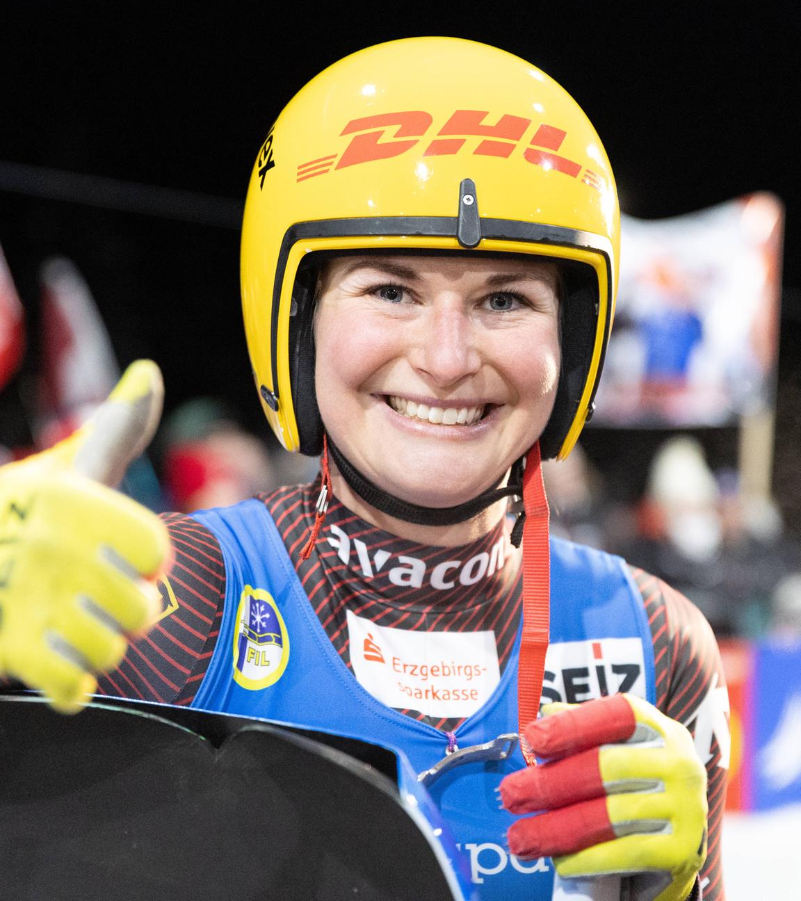 Julia Taubitz hält einen Daumen hoch und lächelt in die Kamera