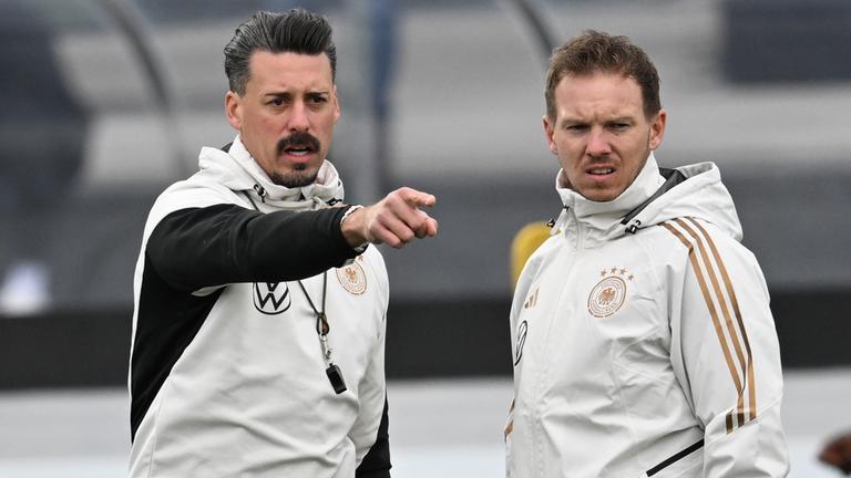 Bundestrainer Julian Nagelsmann (r) und Co-Trainer Sandro Wagner stehen beim Training der Nationalmannschaft auf dem DFB-Campus zusammen. (14.11.2023)