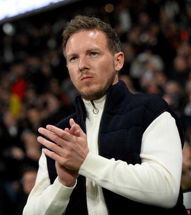Fußball-Bundestrainer Julian Nagelsmann klatscht bei einem Freundschaftspiel gegen die Niederlande. Im Hintergrund Fans auf den Rängen.