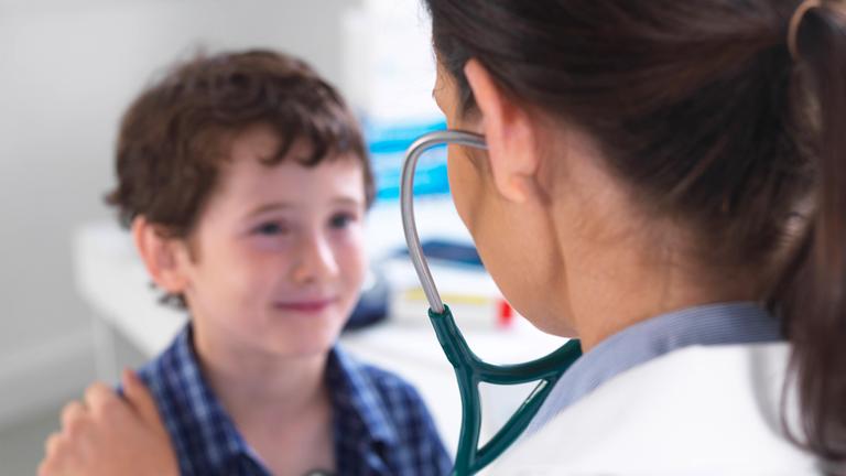 Symbolbild: Eine junge Ärztin bei der Untersuchung eines jungen Patienten