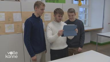 Drei junge Männer schauen auf ein iPad