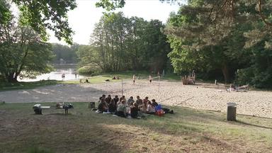 junge Leute auf einer Wiese am See