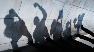 Der Schatten von jungen Menschen mit Smartphones und Tablets ist an einer Wand zu sehen.