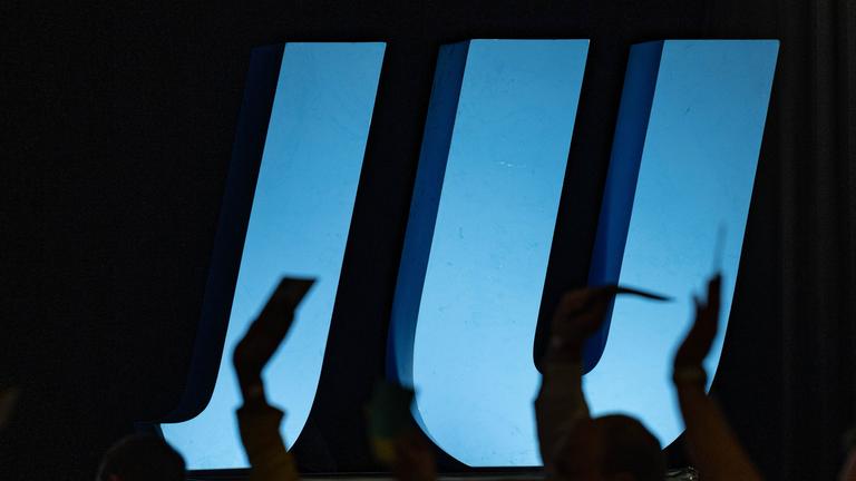 08.10.2021, Bayern, Deggendorf: Delegierte heben auf einer Landesversammlung der Jungen Union vor dem Logo der JU ihre Stimmkarten.