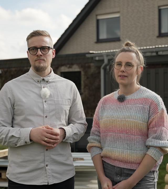 Junges Paar stehen vor einem Einfamilienhaus