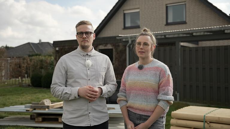 Junges Paar stehen vor einem Einfamilienhaus