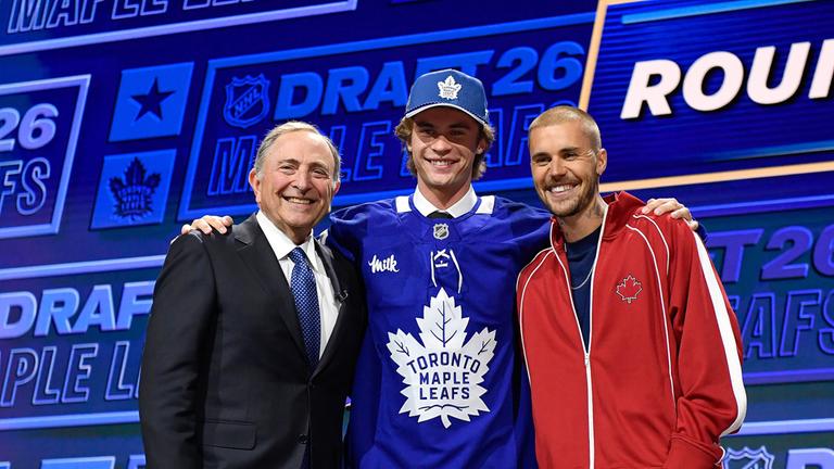  Gavin McKenna (M) steht neben NHL-Kommissar Gary Bettman (l) und Sänger Justin Bieber (r), nachdem er im Rahmen des NHL-Eishockey-Drafts von den Toronto Maple Leafs ausgewählt wurde.