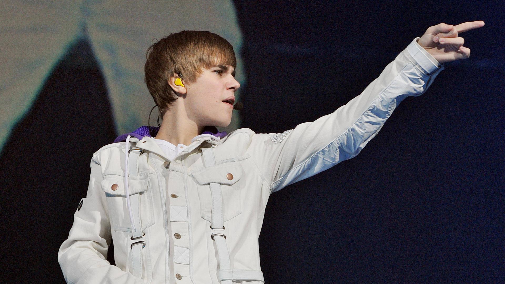 Justin Bieber blickt und zeigt mit ausgestrecktem Arm nach rechts