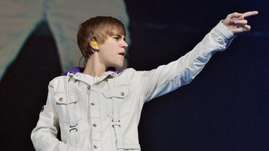 Justin Bieber blickt und zeigt mit ausgestrecktem Arm nach rechts