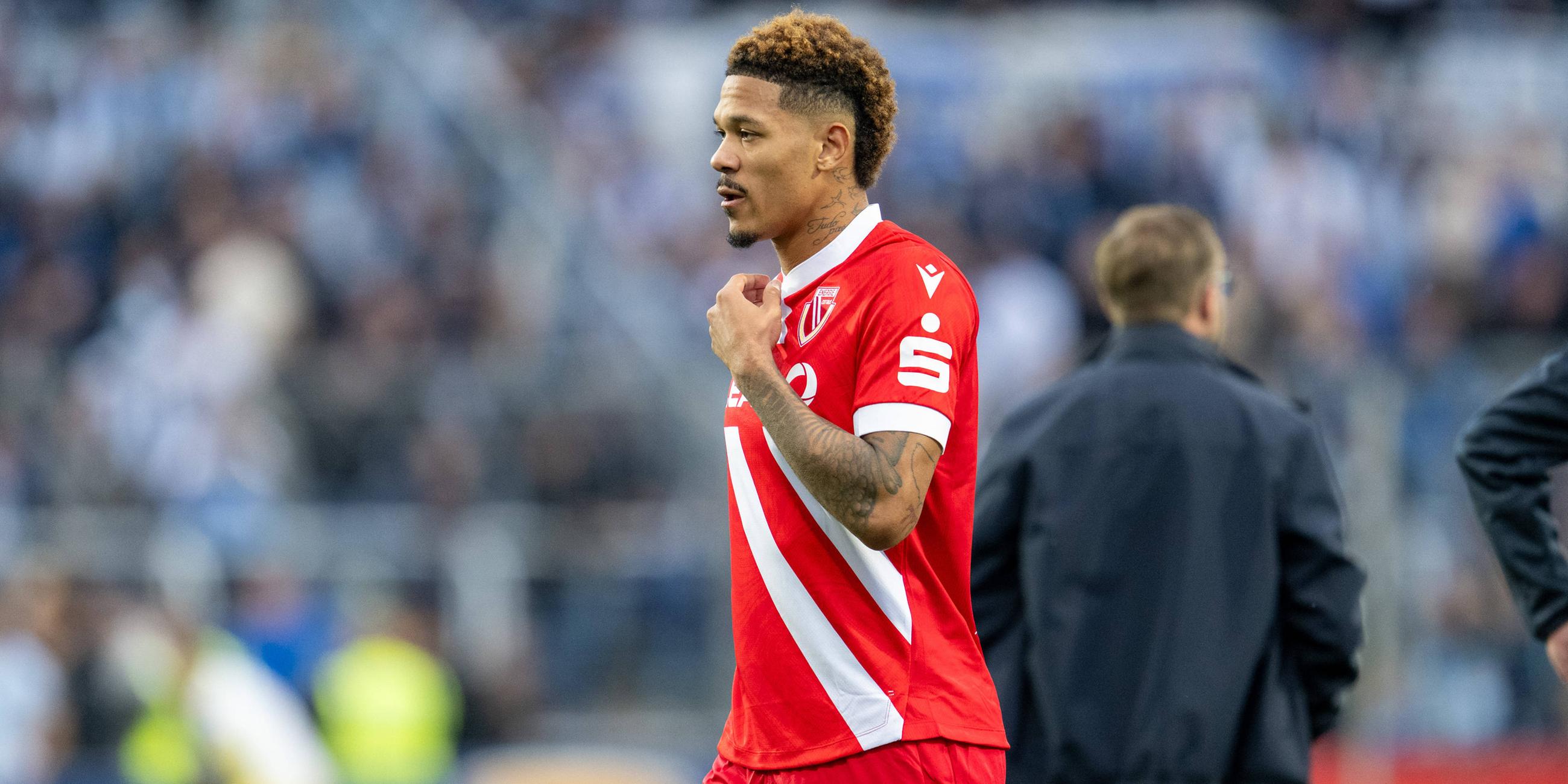 Justin Butler geht alleine mit bedrücktem Blick über das Spielfeld