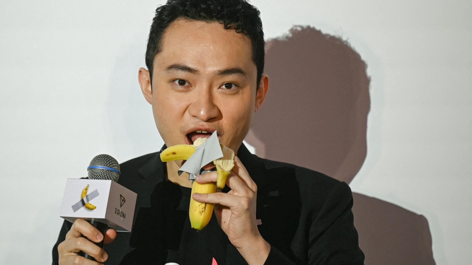 Der in China geborene Krypto-Gründer Justin Sun isst in Hongkong ein Bananenkunstwerk