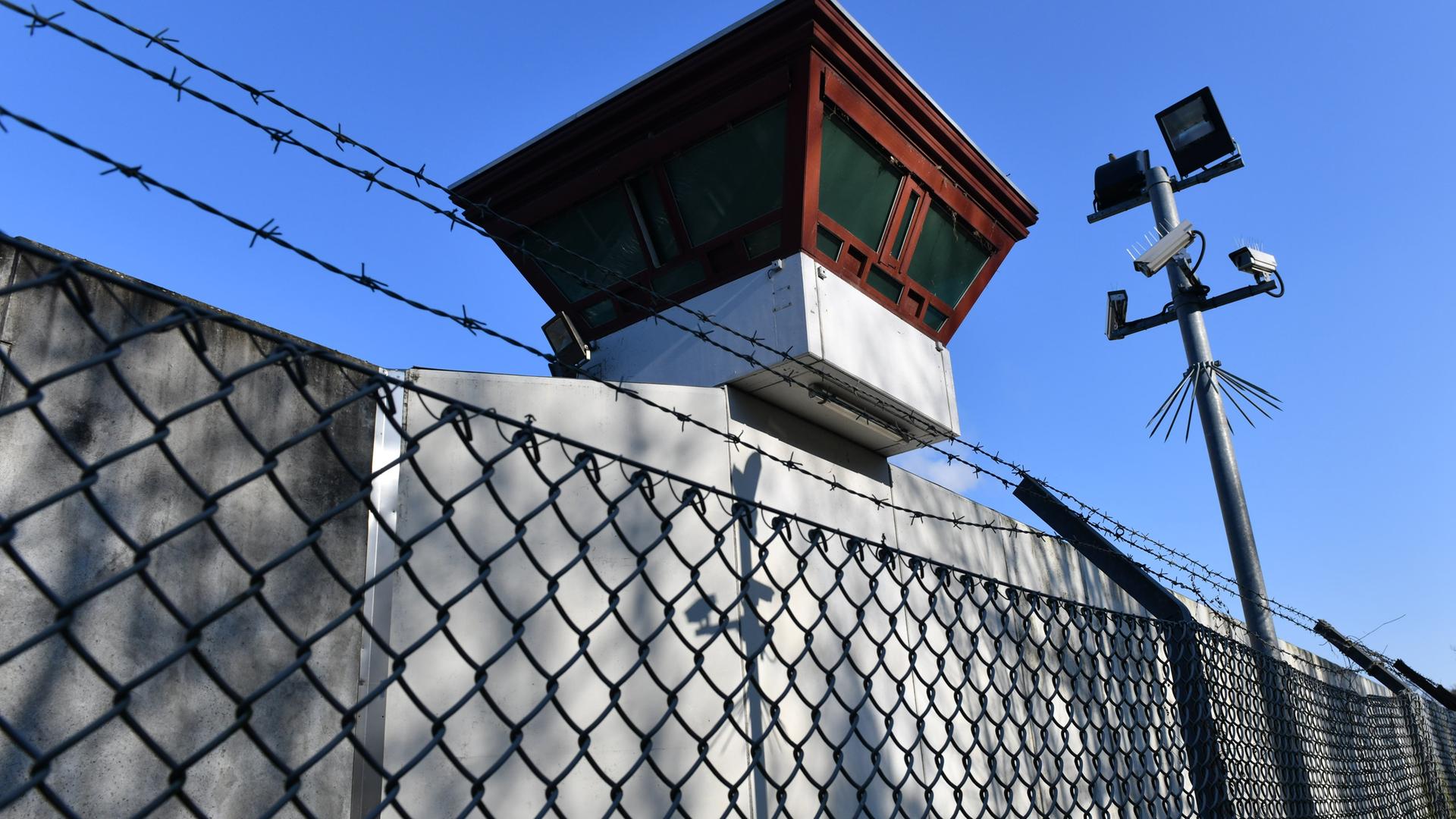 Sicherheitsleuchten und Überwachungskameras sind vor einem Gebäude auf dem Gelände der Justizvollzugsanstalt Tegel zu sehen. 