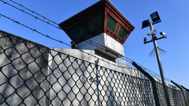 Sicherheitsleuchten und Überwachungskameras sind vor einem Gebäude auf dem Gelände der Justizvollzugsanstalt Tegel zu sehen. 