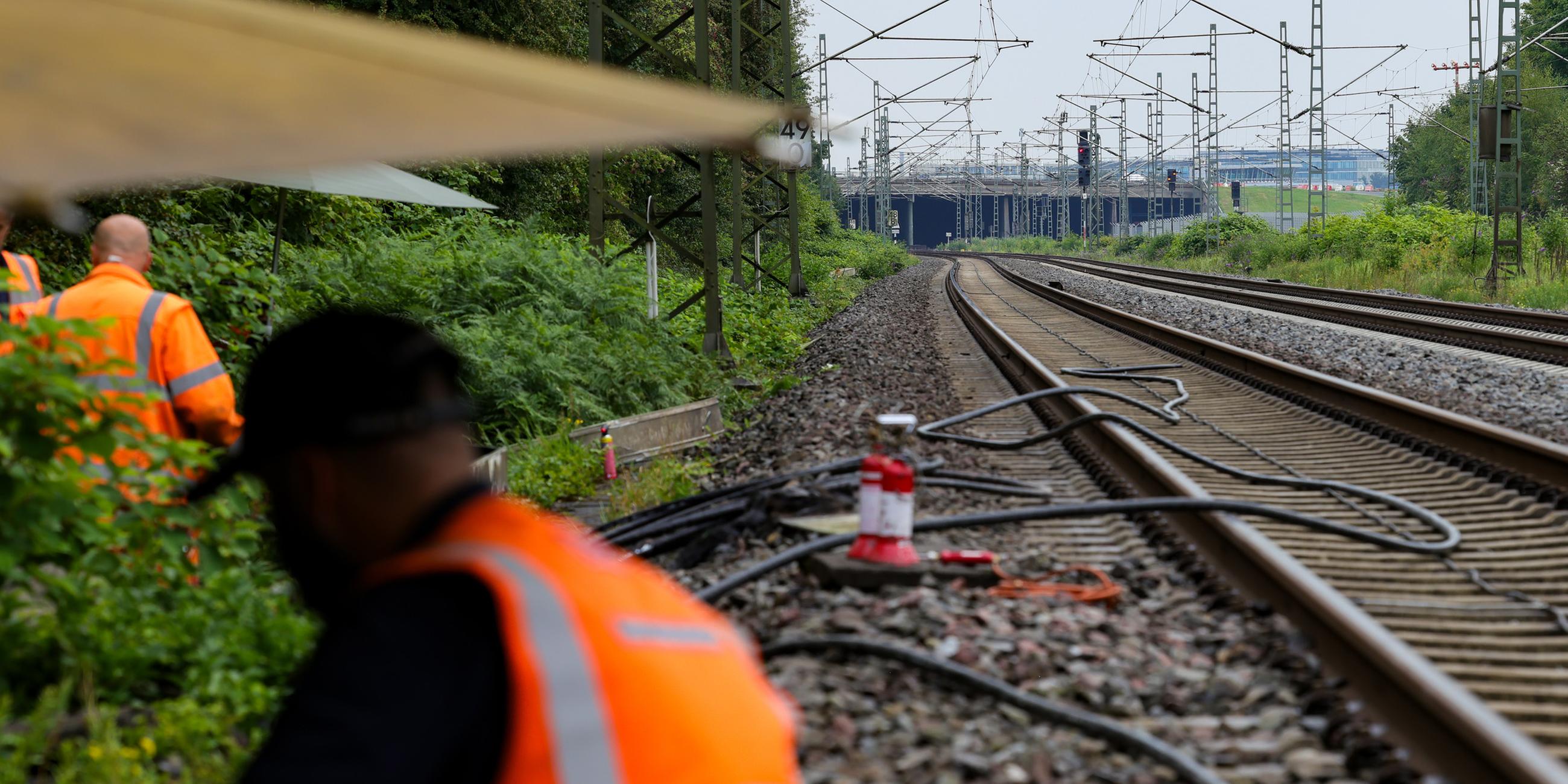 Mitarbeiter der Deutschen Bahn bei der Repatarur von Kabeln an einem Gleisabschnitt in Düsseldorf, nachdem neben der Bahnstrecke Feuer in einem Kabeltunnel gelegt wurde.