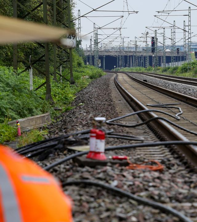 Mitarbeiter der Deutschen Bahn bei der Repatarur von Kabeln an einem Gleisabschnitt in Düsseldorf, nachdem neben der Bahnstrecke Feuer in einem Kabeltunnel gelegt wurde.