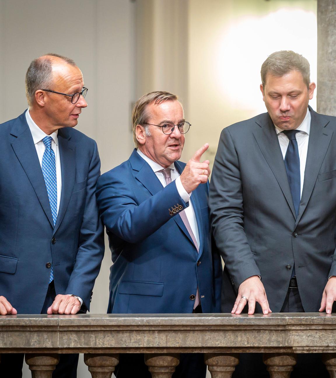 Von links nach rechts: Friedrich Merz, Boris Pistorius, Lars Klingbeil und Andreas Scheuer stehen vor einem Geländer im Verteidigungsministerium nach der Debatte über ein neues Wehrdienst-Gesetz.