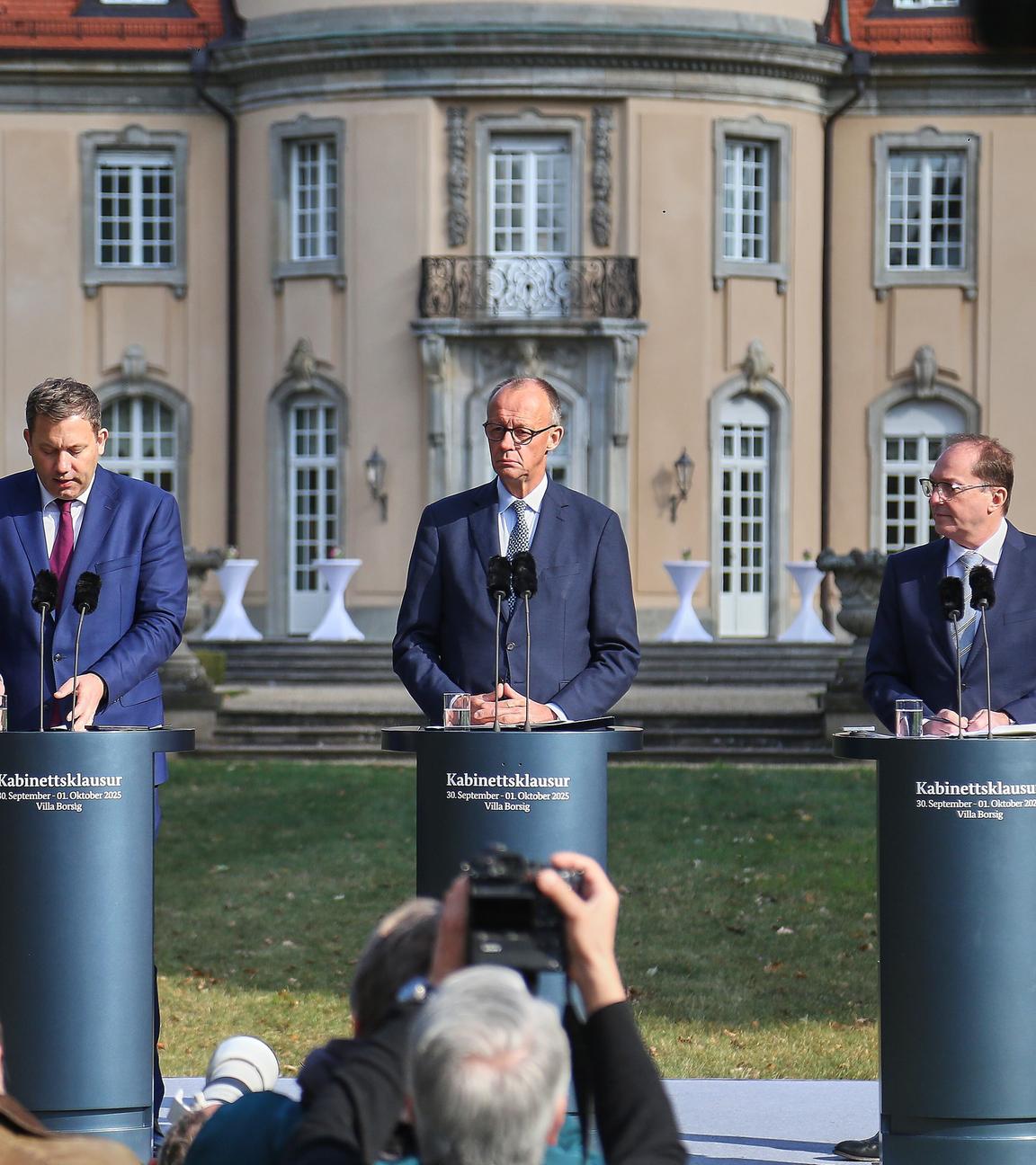 Auf dem Bild sind sind Bundesinnenminister Alexander Dobrindt, Bundeskanzler Friedrich Merz und Bundesminister der Inneren Lars Klingbeil zu sehen. Sie befinden sich zu dritt als Sprecher auf einer Pressekonferenz bezüglich der Kabinettsklausur.