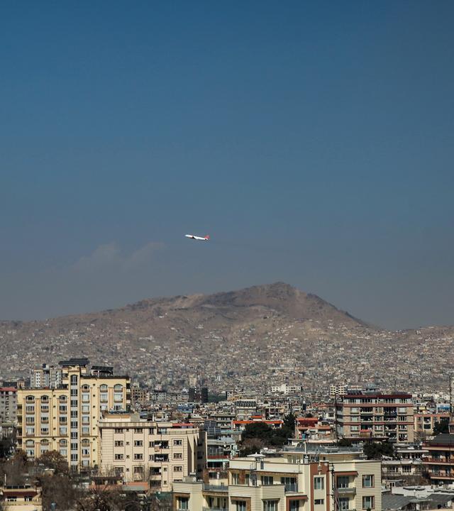 Ein Flugzeug fliegt über Wohn- und Geschäftshäuser, Kabul, Afghanistan.