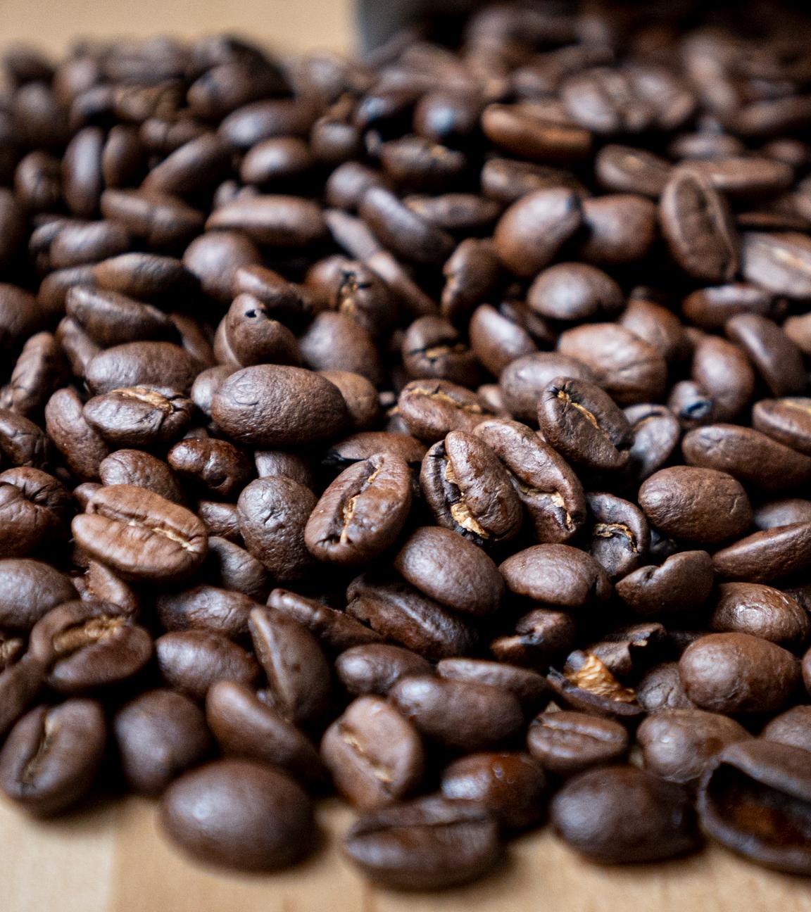 Berlin: Geröstete Kaffeebohnen liegen auf einem Tisch.