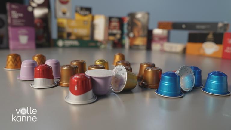 Kaffeekapseln verschiedener Marken liegen gesammelt auf einem Tisch