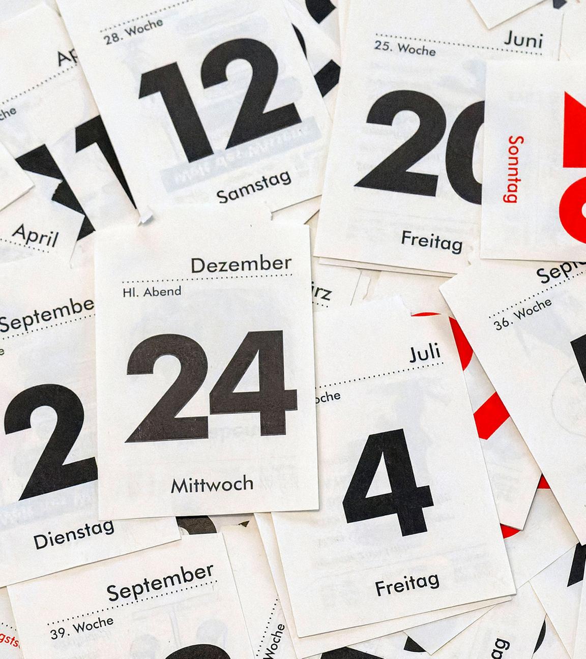 Kalenderblätter liegen auf einem Tisch.