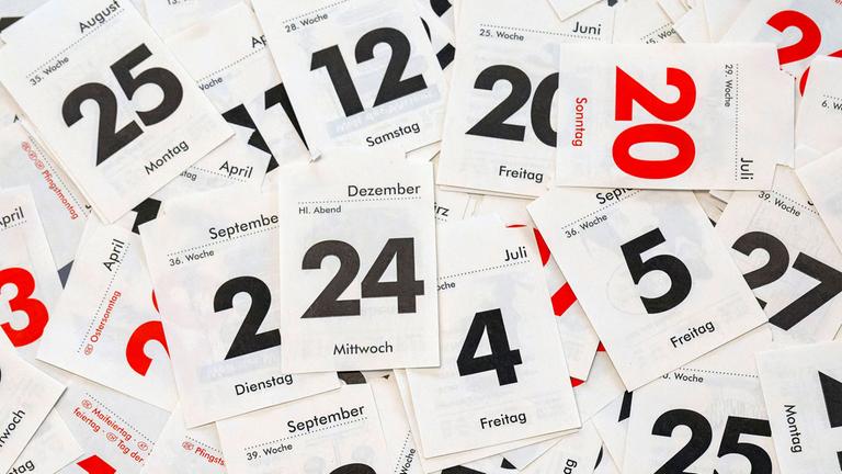 Kalenderblätter liegen auf einem Tisch.