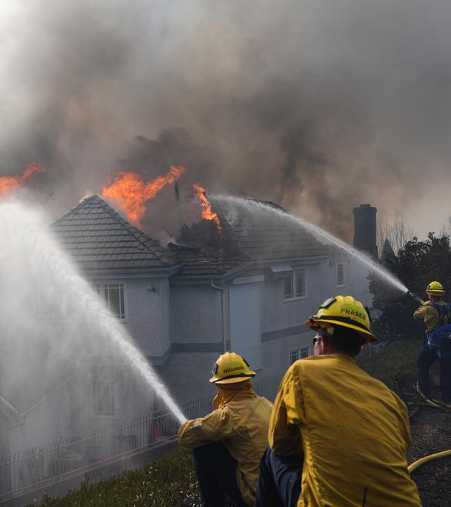 Feuerwehrleute löschen ein brennendes Haus in San Juan Capistrano, Kalifornien.