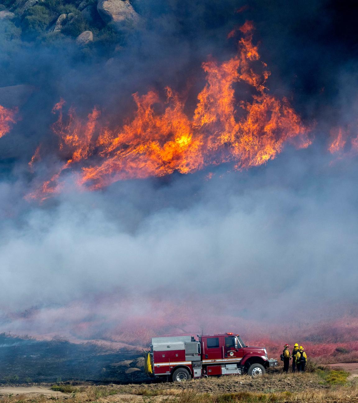 Feuerwehrleute des Pechanga Fire Department überwachen die Feuerlinie der Brandfront in Moreno Valley, Kalifornien.
