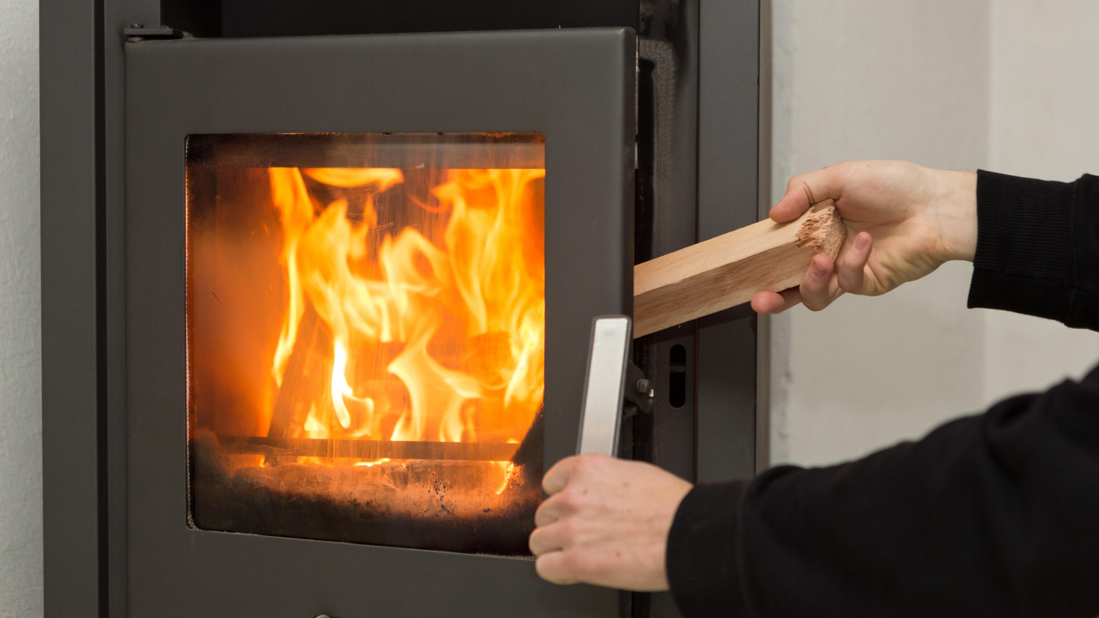 Ein brennender Kamin, der gerade mit Holz befeuert wird
