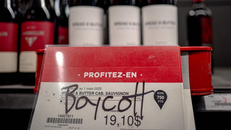 In einem Supermarkt in Montreal liegt vor amerikanischem Wein ein Schild, auf dem "Boycott" handgeschrieben steht.