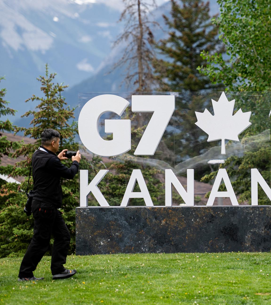 Ein Journalist fotografiert ein Schild, das für den G7-Gipfel im Internationalen Medienzentrum auf dem Gelände des Banff Centre for Arts and Creativity in Banff, Kanada wirbt.