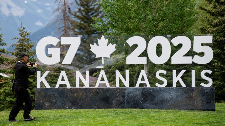 Ein Journalist fotografiert ein Schild, das für den G7-Gipfel im Internationalen Medienzentrum auf dem Gelände des Banff Centre for Arts and Creativity in Banff, Kanada wirbt.