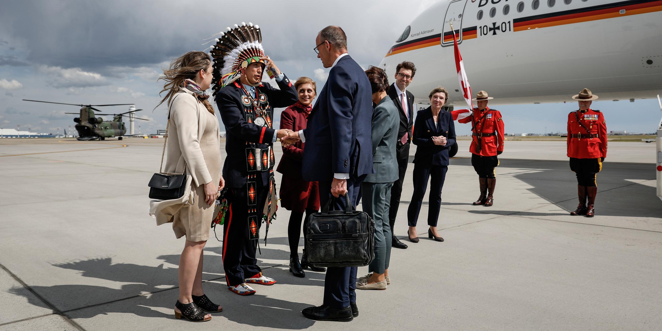 Kanzler Merz wird am Flughafen von Calgary von Steven Crowchild von den Tsuut'ina First Nation begrüßt.
