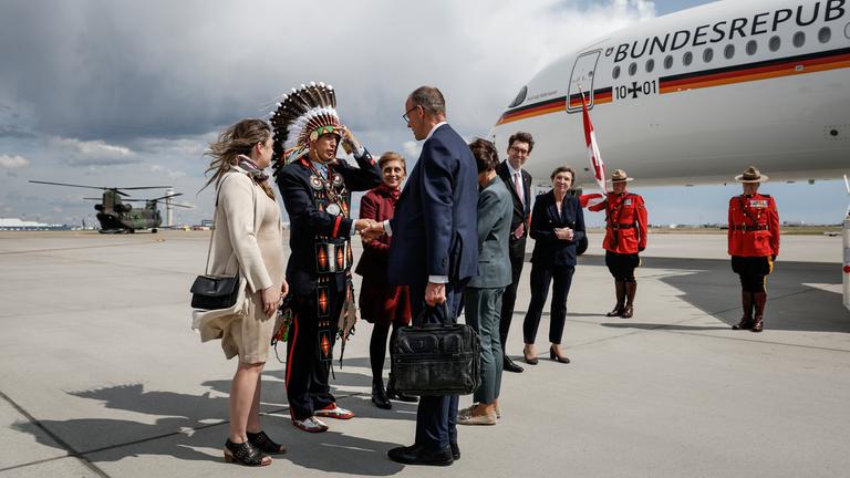 Kanzler Merz wird am Flughafen von Calgary von Steven Crowchild von den Tsuut'ina First Nation begrüßt.