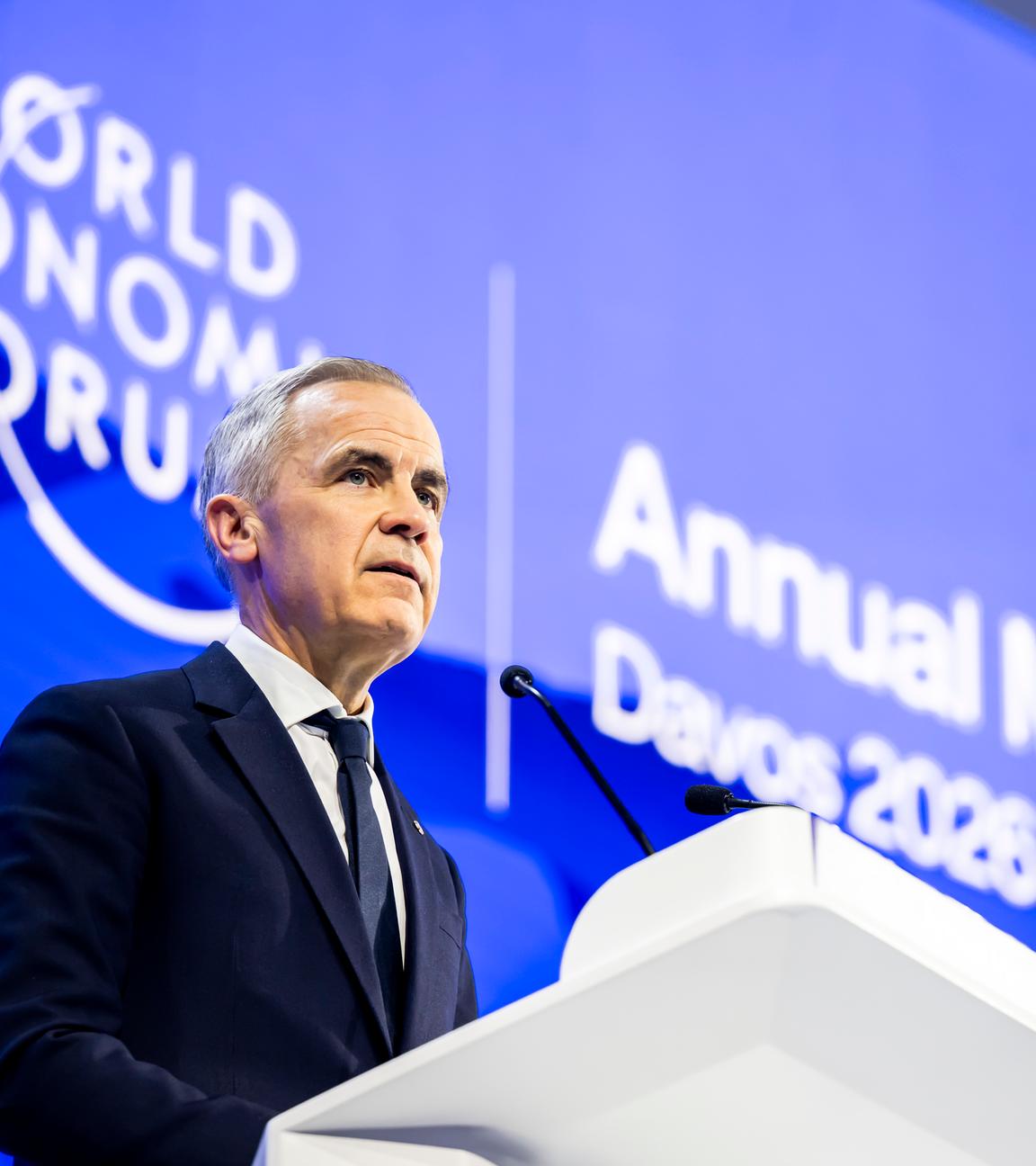 Mark Carney steht hinter einem Rednerpult vor blauem Hintergrund, auf dem "World Economic Forum" steht.