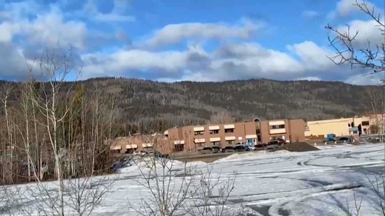 Die Schule in Tumbler Ridge, Kanada, umgeben von Hügeln und schneebedeckten Wiesen.