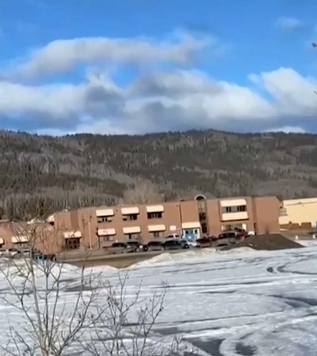 Die Schule in Tumbler Ridge, Kanada, umgeben von Hügeln und schneebedeckten Wiesen.