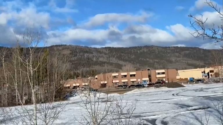 Die Schule in Tumbler Ridge, Kanada, umgeben von Hügeln und schneebedeckten Wiesen.