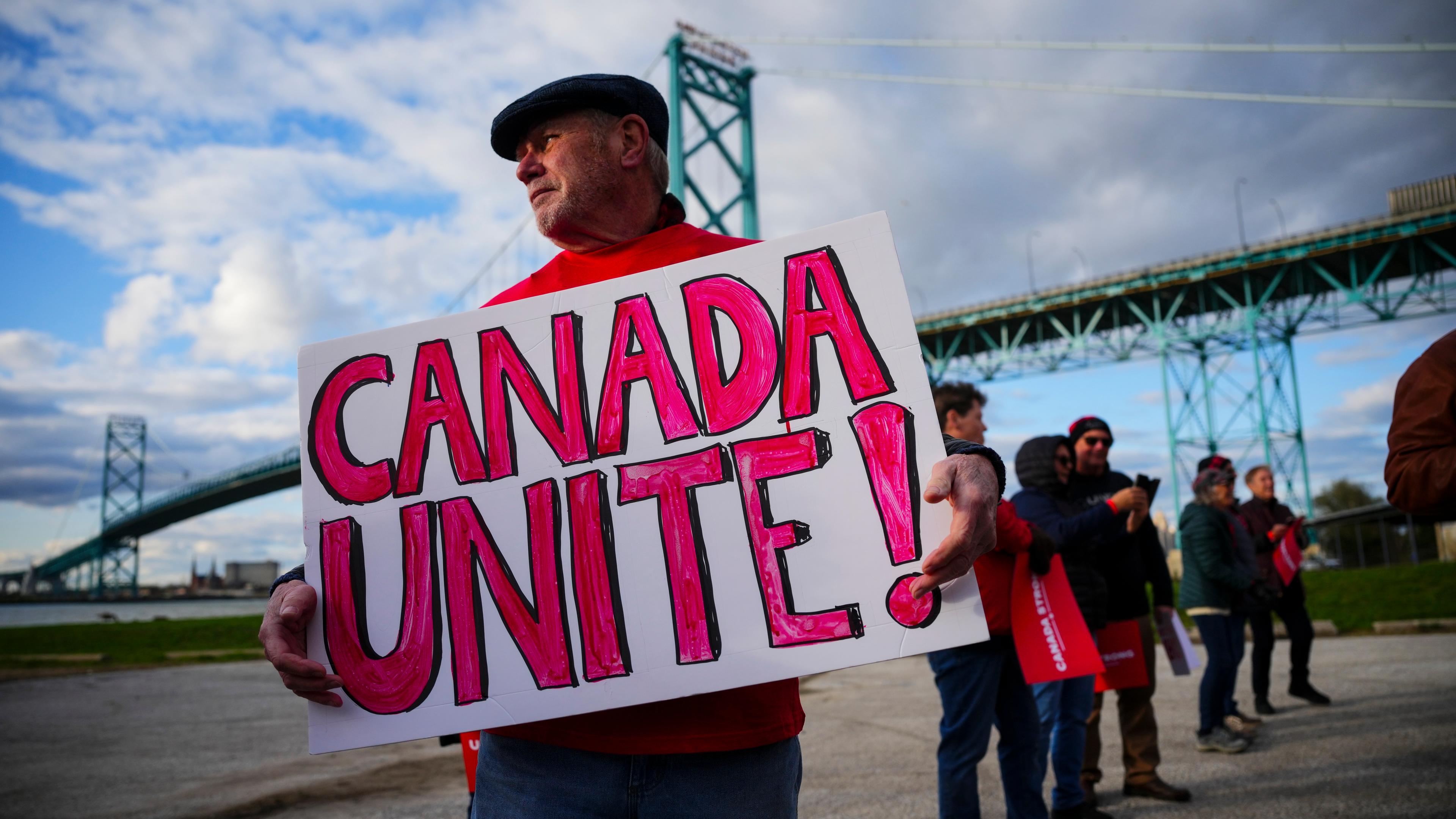 Ein Unterstützer des liberalen Kandidaten Mark Carney hält ein Schild mit der Aufschrift "Canada Unite"
