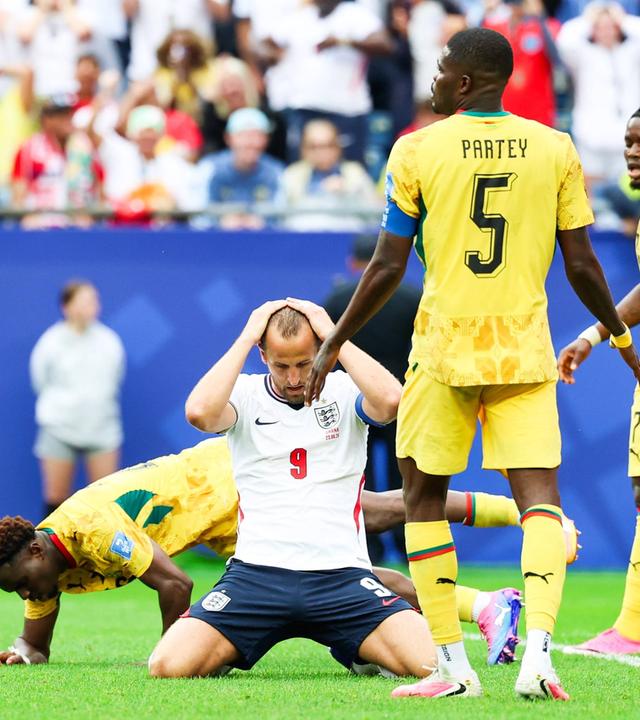 Harry Kane kniet auf dem Boden und fährt sich durch die Haare.