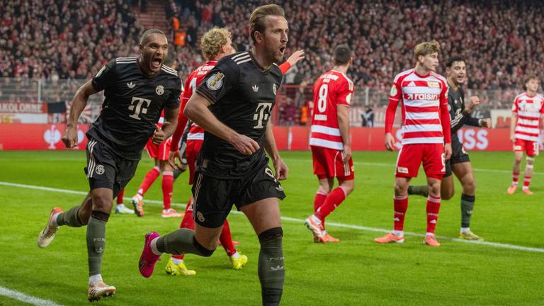 Jonathan Tah läuft jubelnd seinem Teamkollegen Harry Kane hinterher, nachdem dieser das 2:0 für den FC Bayern München per Kopf erzielte