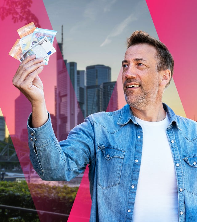 ZDF-Moderator hält ein Bündel Geldscheine in der Hand vor einem Graphik-Hintergrund mit der Skyline von Frankfurt