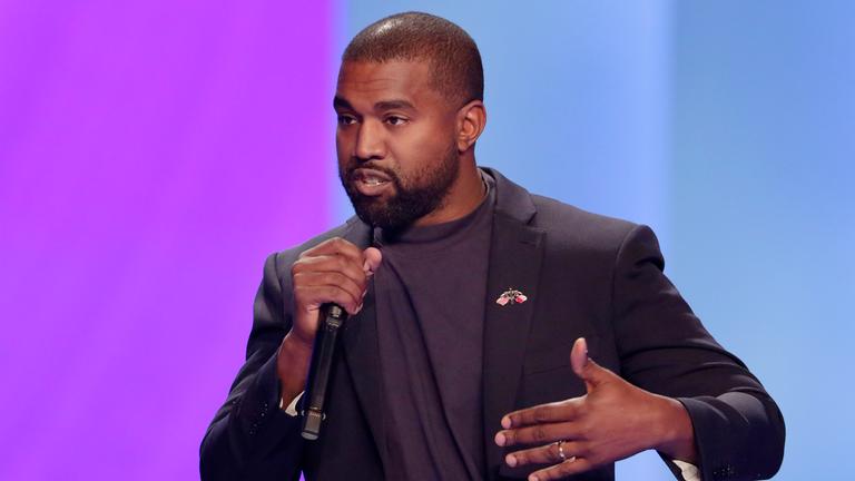 Kanye West spricht in ein Mikrofon.